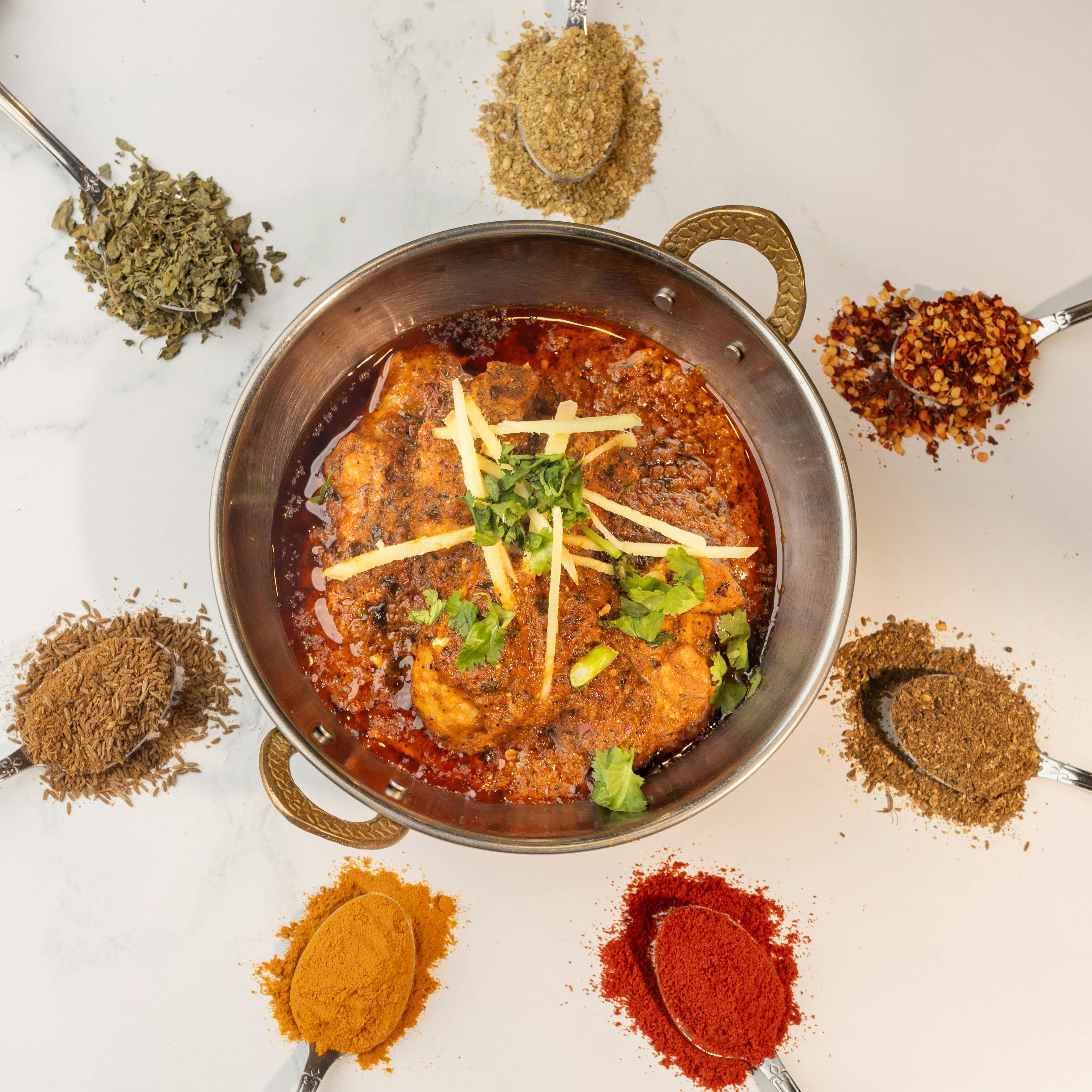 Ancient manuscripts and handpicked whole spices on a stone surface - Nosh Caterers on Pexels